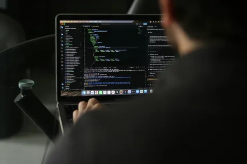 Developer working in a dark-themed code editor on a laptop screen