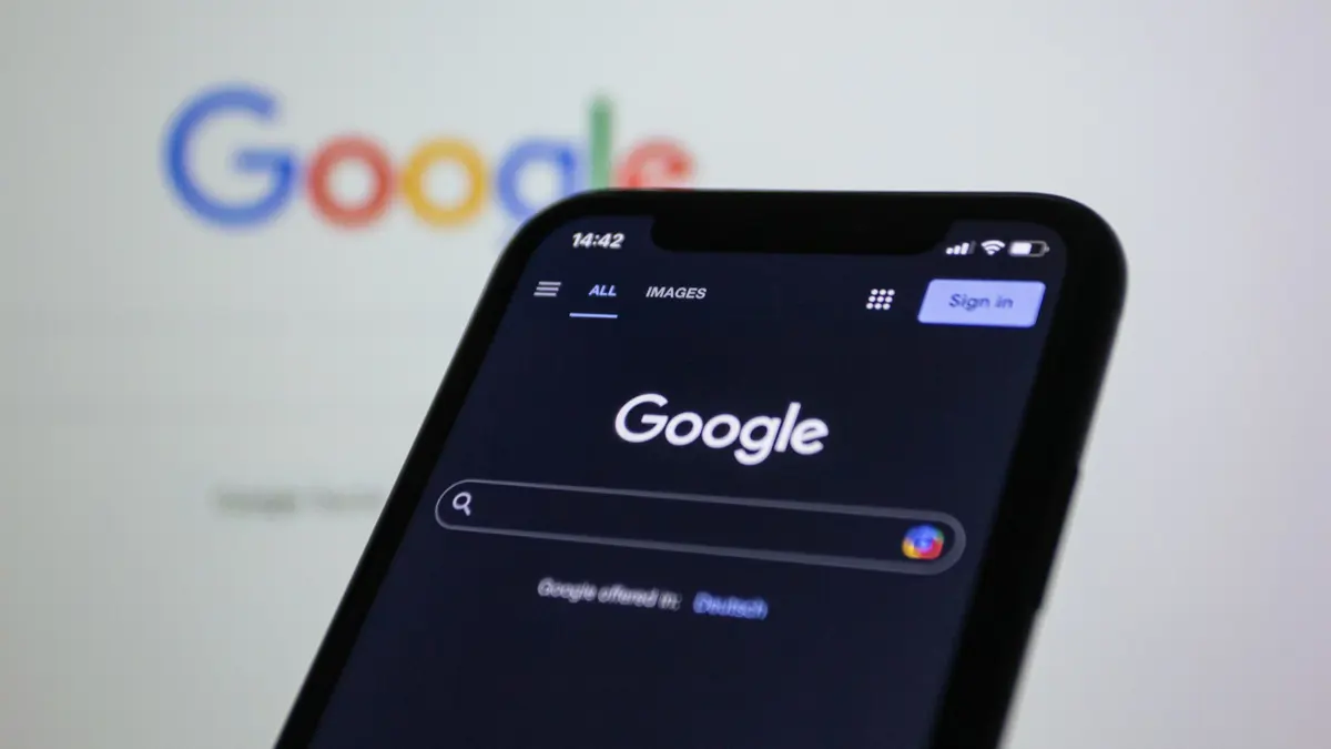 Google Search homepage displayed on a smartphone in dark mode with the Google logo blurred in the background