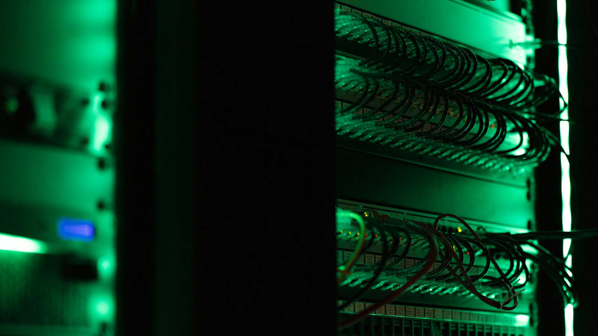 Row of server racks in a large data center with blue LED lighting