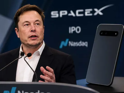 Elon Musk speaking at the Nasdaq during SpaceX's IPO, with reporting that SpaceX showed investors a handset-like AI device prototype before the listing