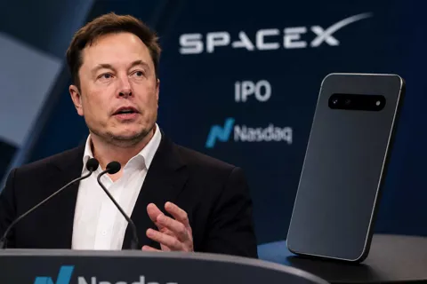 Elon Musk speaking at the Nasdaq during SpaceX's IPO, with reporting that SpaceX showed investors a handset-like AI device prototype before the listing