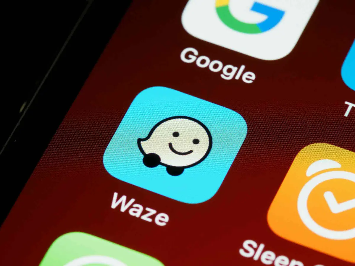 Waze app showing motorcycle mode routing with hazard indicators on a city map
