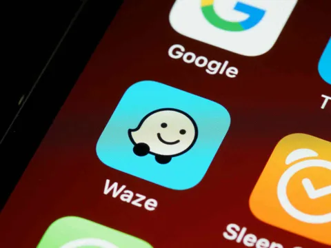 Waze app showing motorcycle mode routing with hazard indicators on a city map