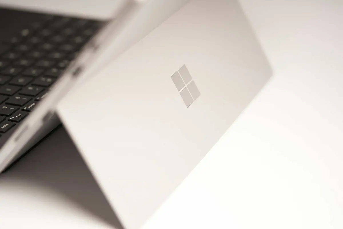 Microsoft Windows and Surface event graphic with a laptop, Windows logo, and local AI theme